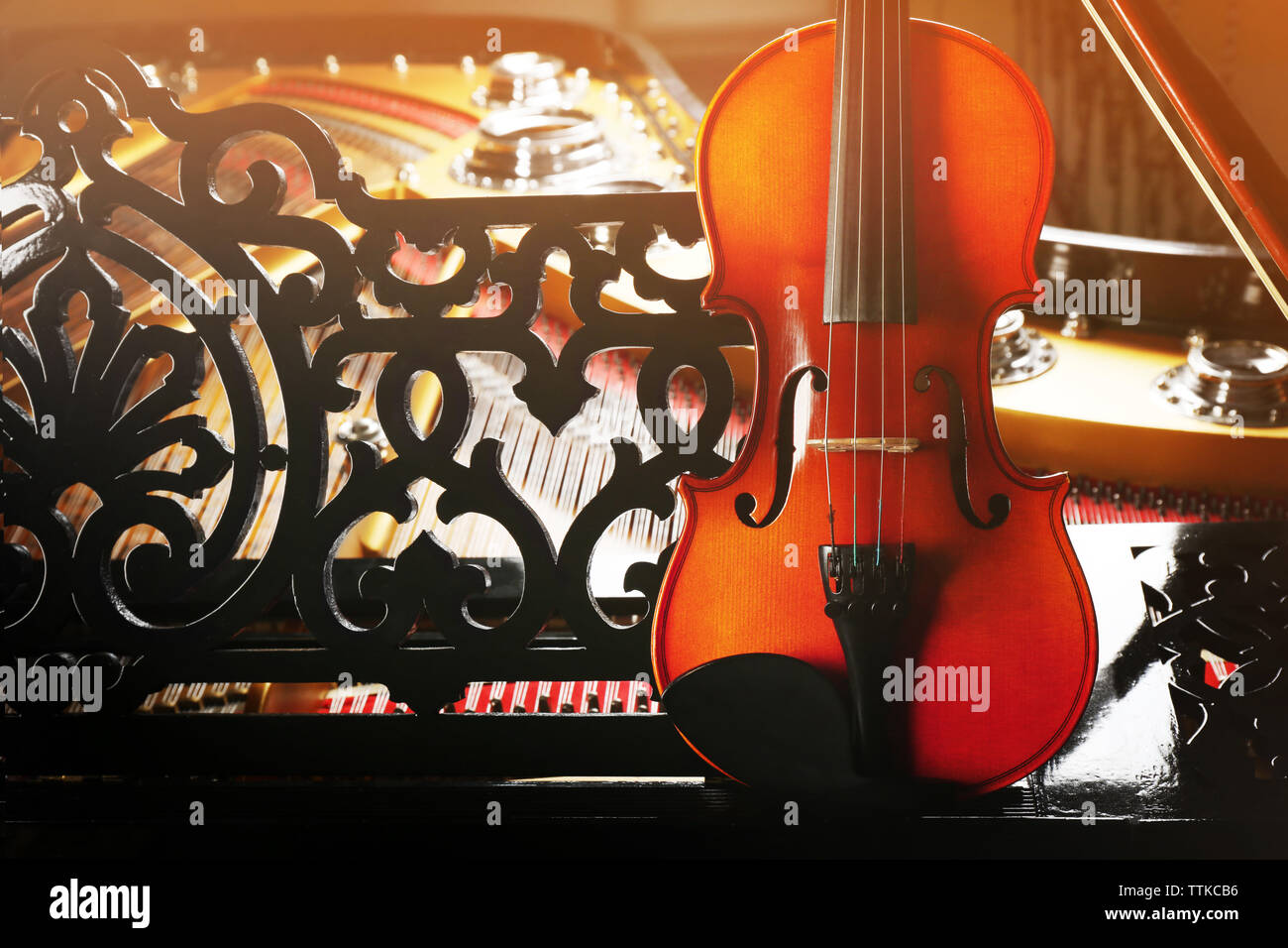 Violin lying on piano, close up Stock Photo