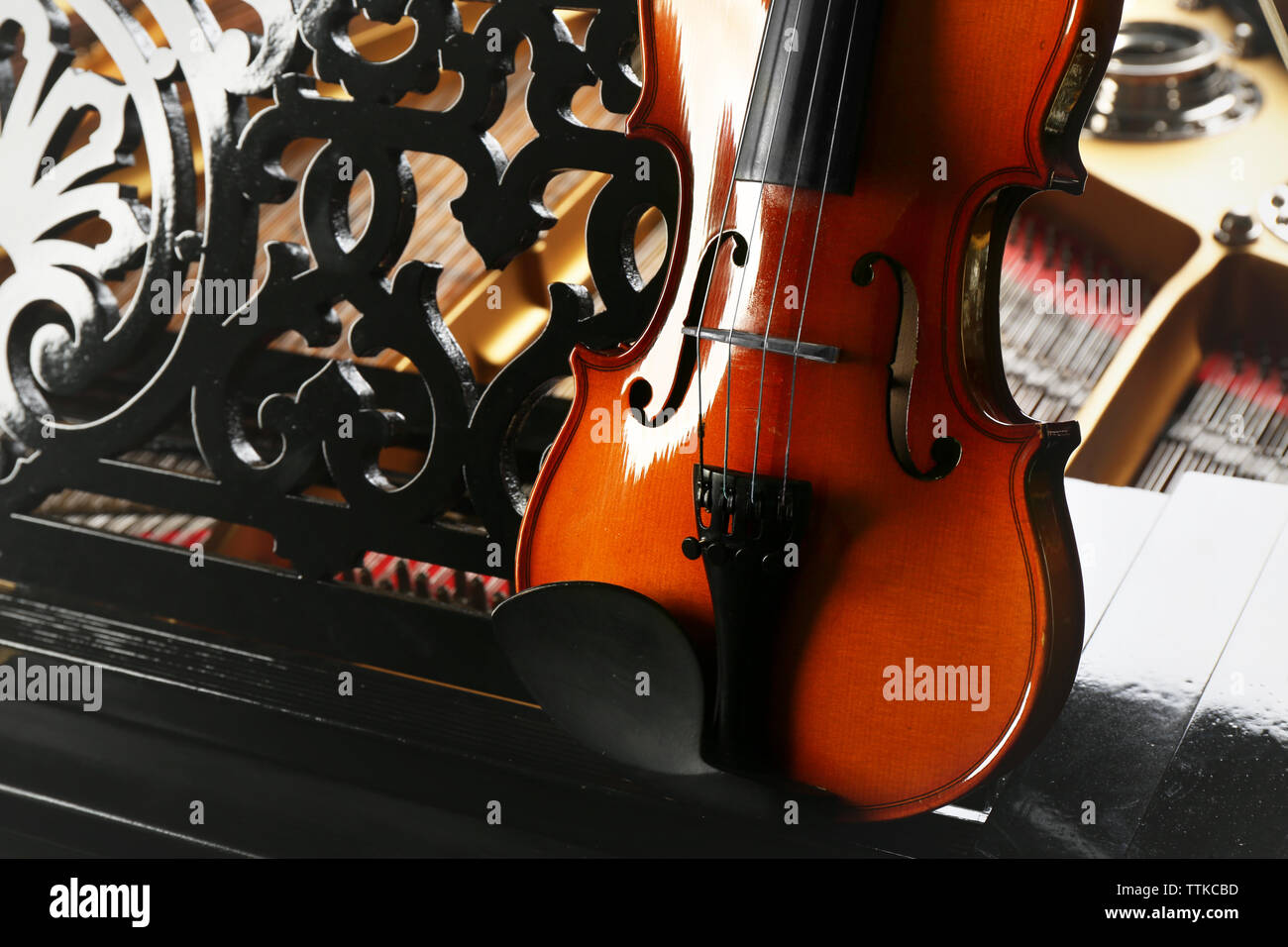 Violin lying on piano, close up Stock Photo