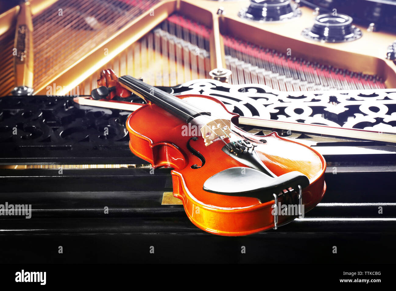 Violin lying on piano, close up Stock Photo