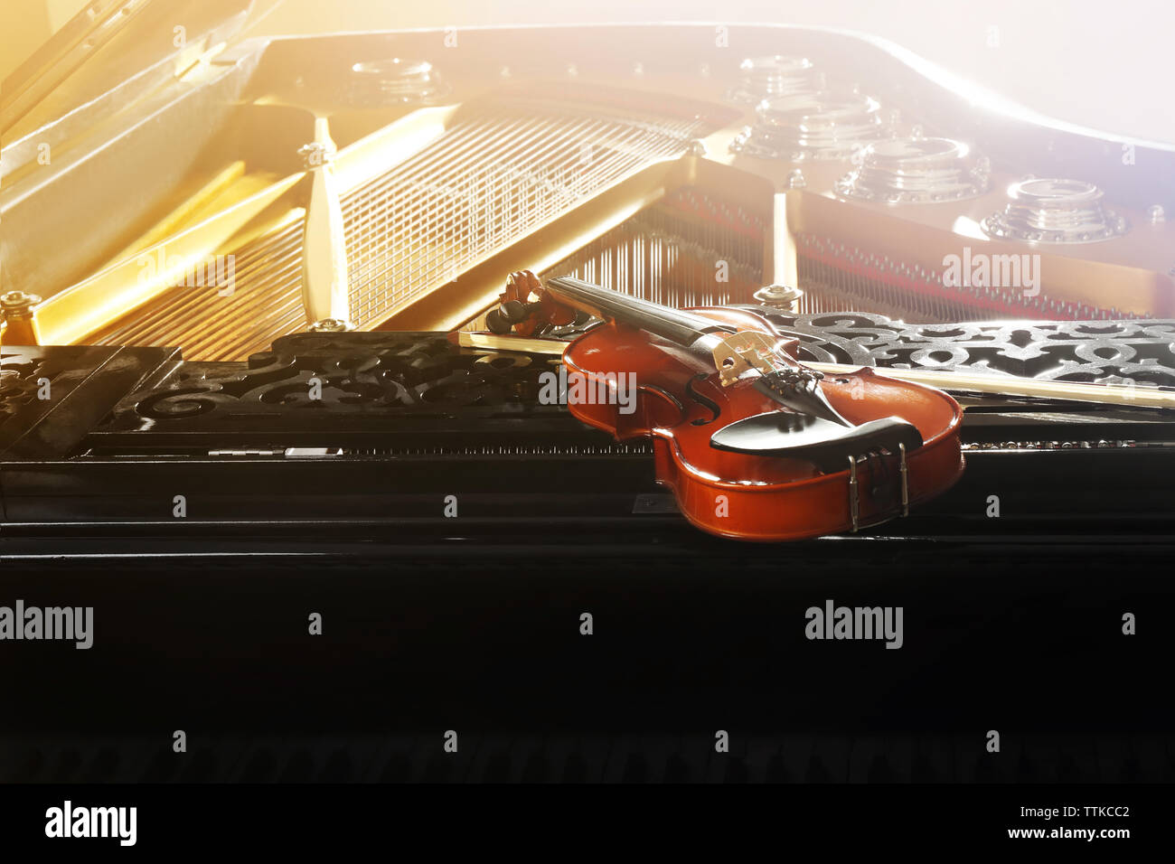 Violin lying on piano, close up Stock Photo