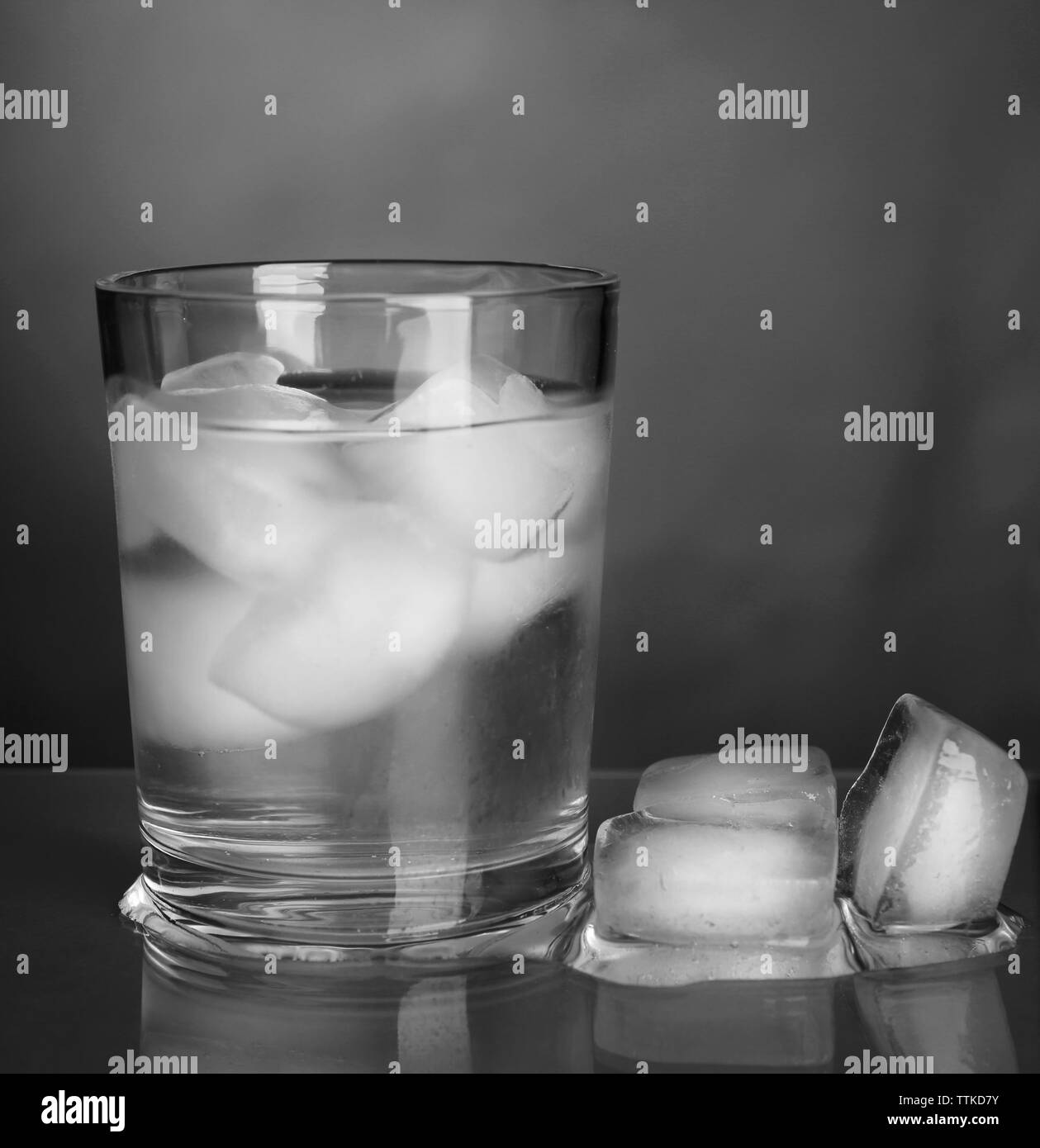 Glass of cold water with ice on grey background Stock Photo - Alamy