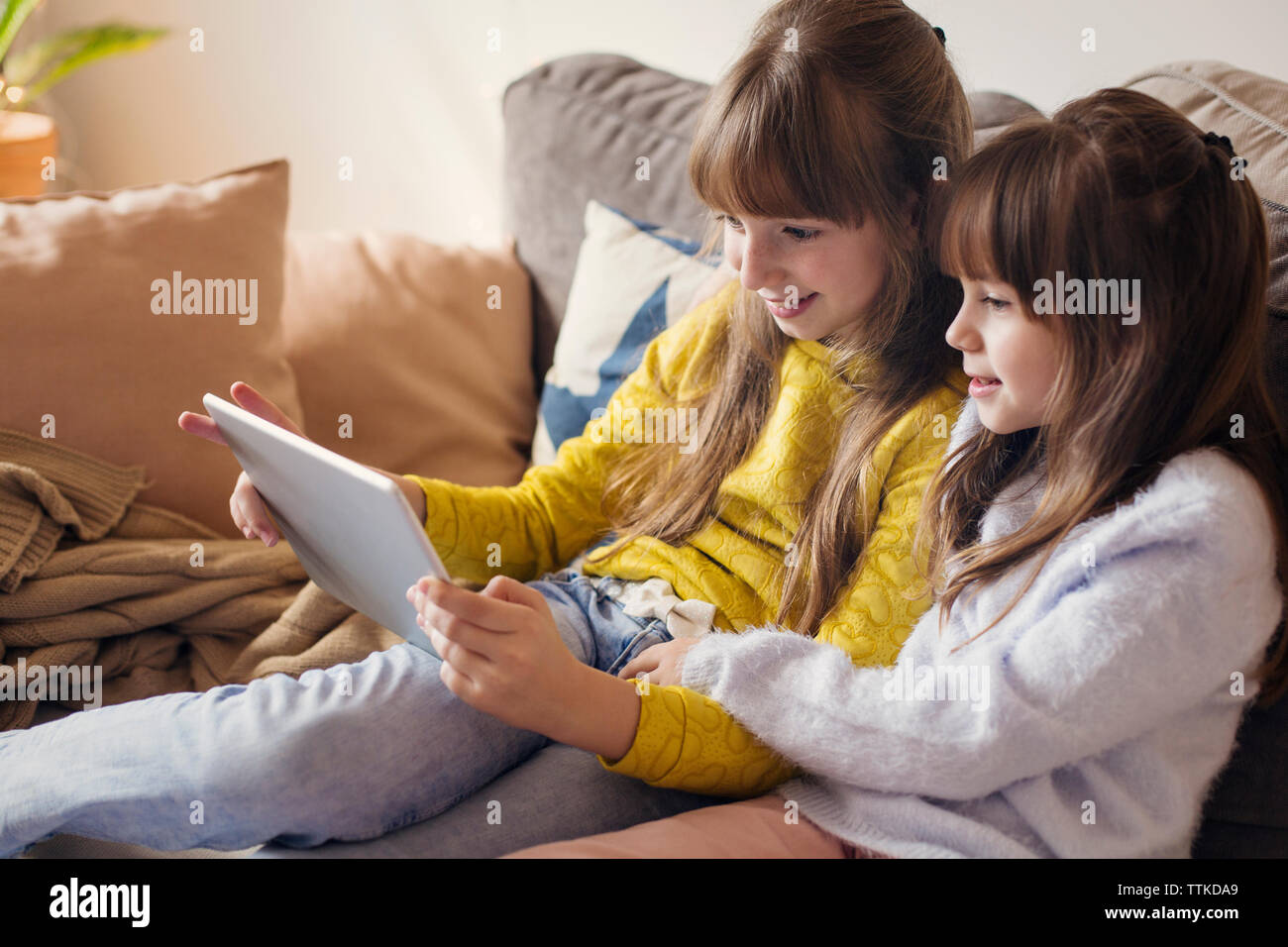 Two sisters sitting sofa hi-res stock photography and images - Alamy