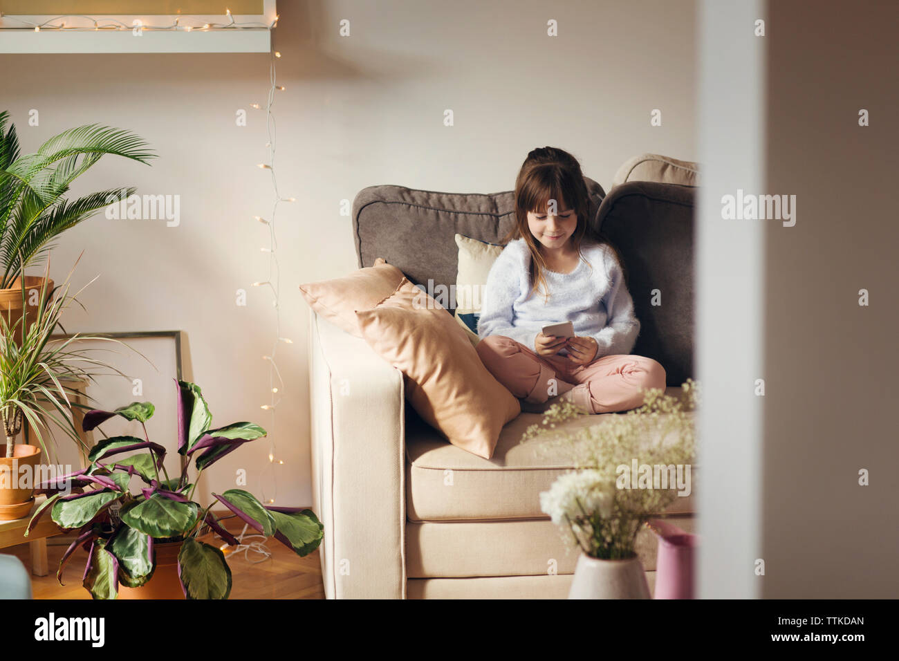 Girl sitting on sofa using hi-res stock photography and images - Alamy