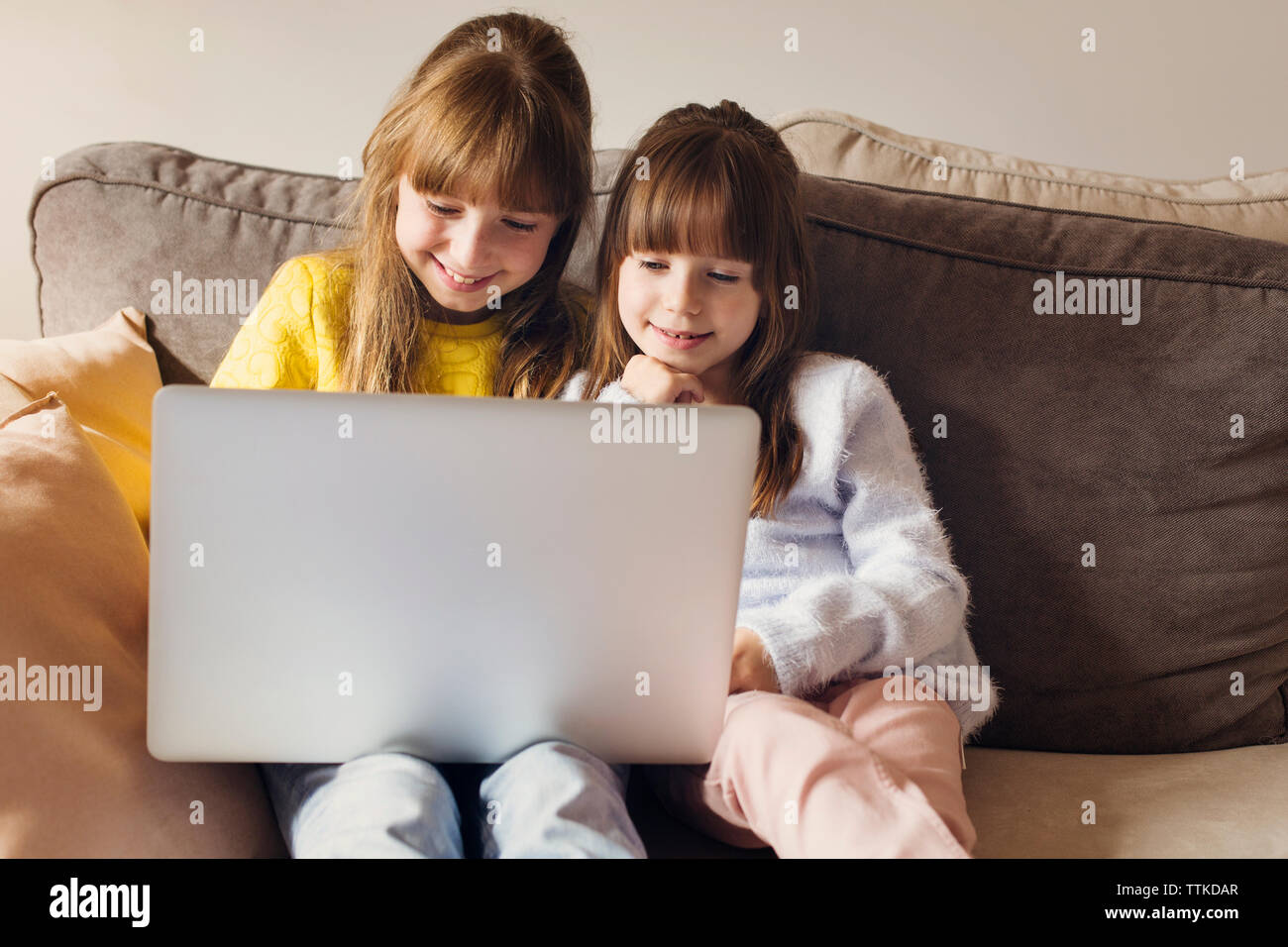 Two sisters sitting on sofa hi-res stock photography and images - Alamy