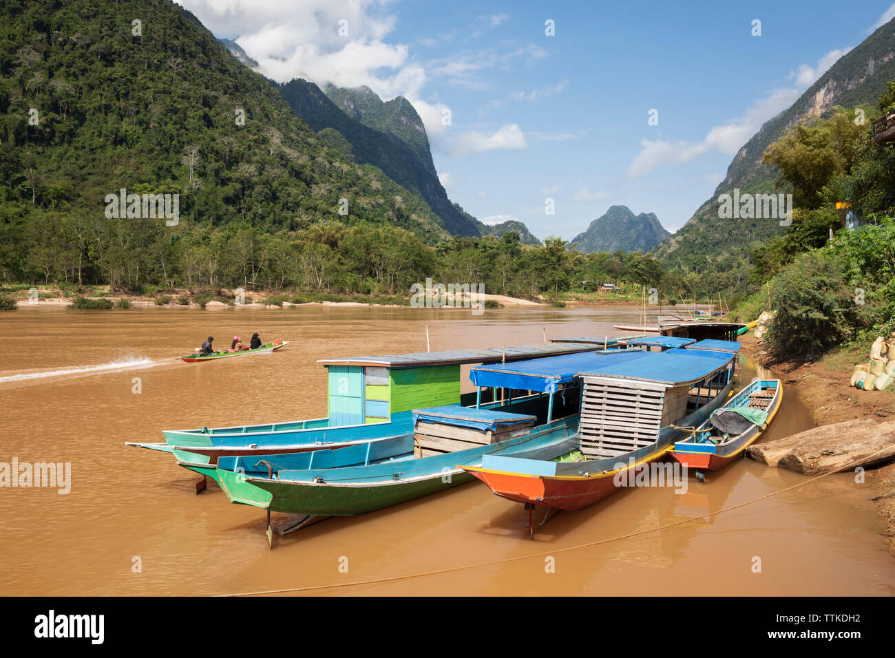 Blue tour boats docked on the Nam Ou River at Muang Ngoi Neua looking north, Muang Ngoi District, Luang Prabang Province, Northern Laos, Laos, SE Asia Stock Photo