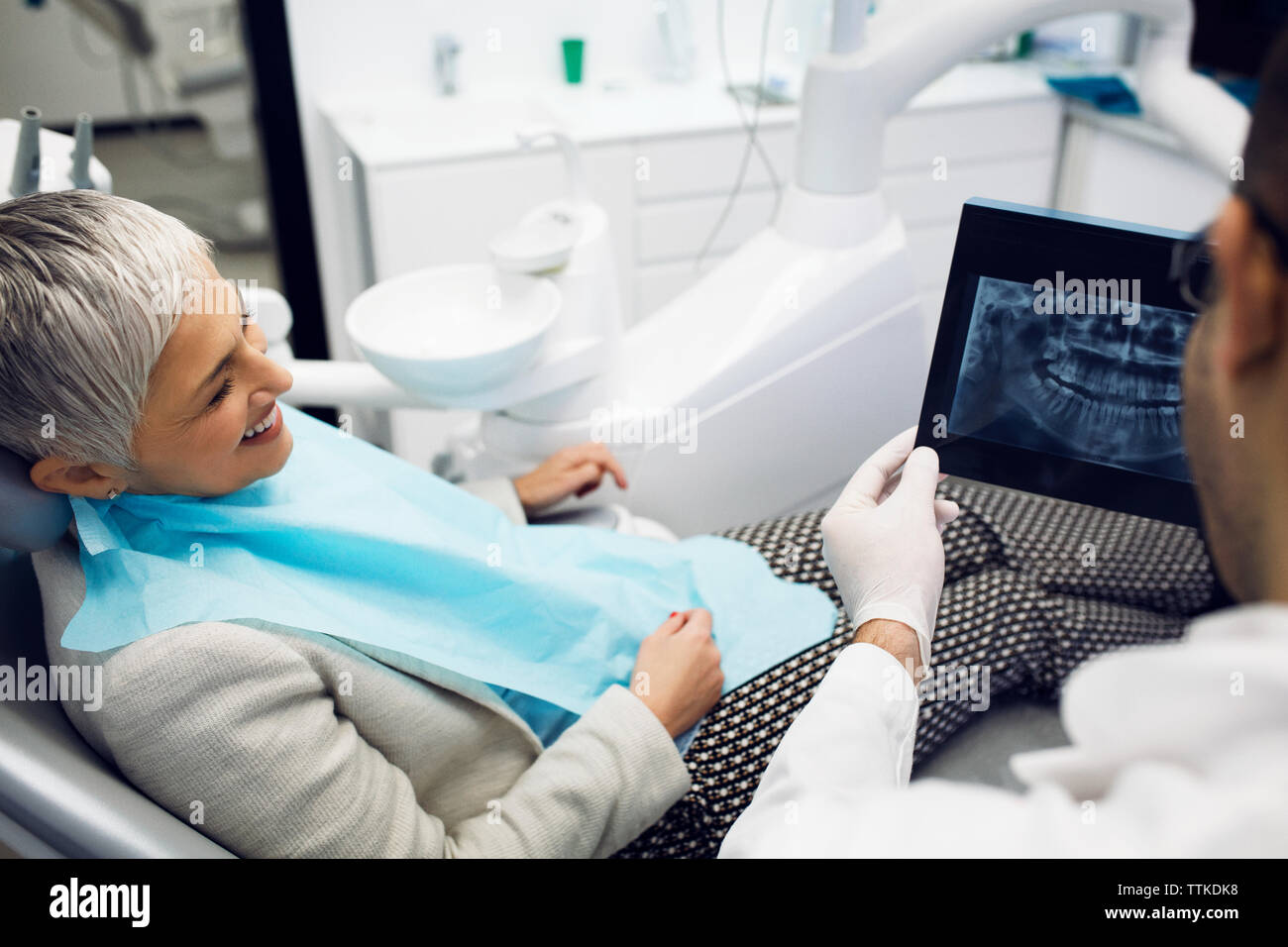 Dentist showing x-ray to happy woman at clinic Stock Photo