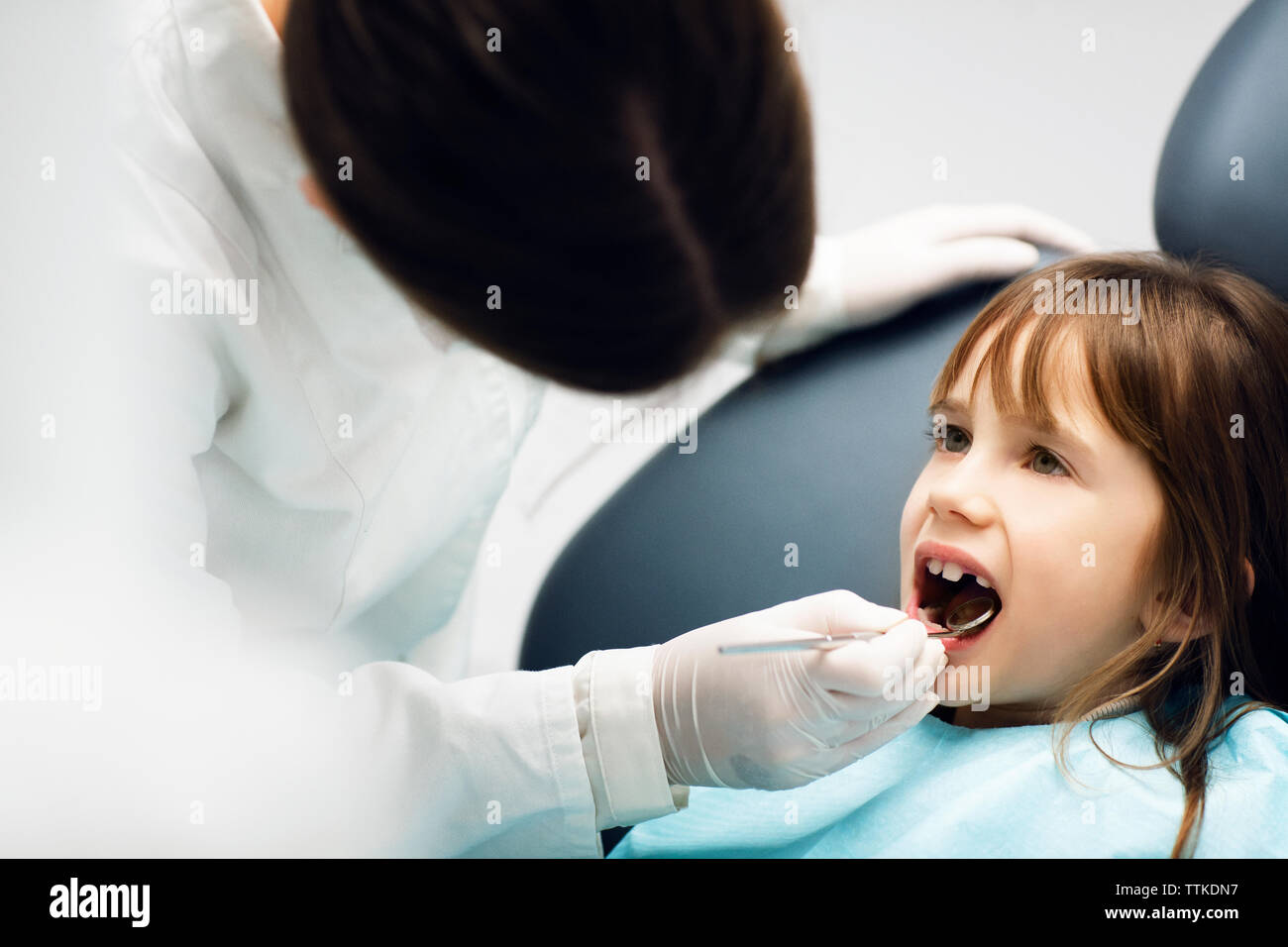 Dentist checking girl's teeth at clinic Stock Photo Alamy