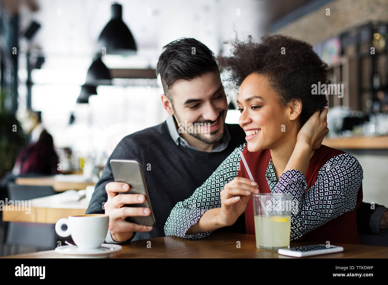 Happy business couple using mobile phone in cafe Stock Photo