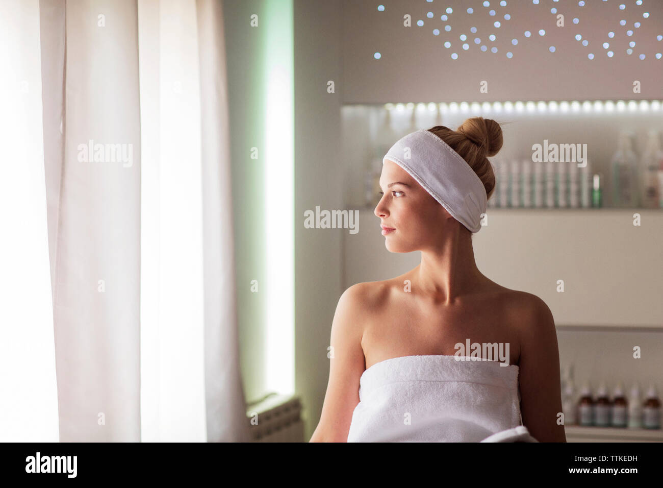 Thoughtful woman sitting at health spa Stock Photo