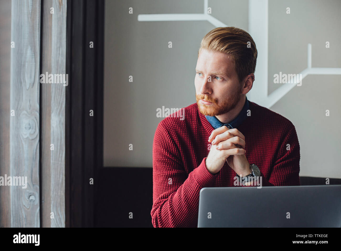 Thoughtful businessman sitting with hands clasped in restaurant Stock Photo