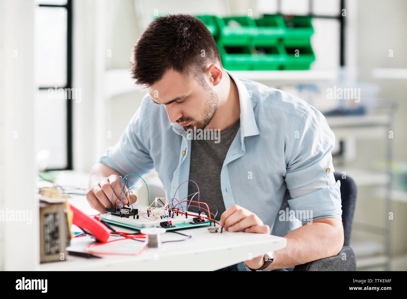 Engineer wiring circuit at table in electronics industry Stock Photo