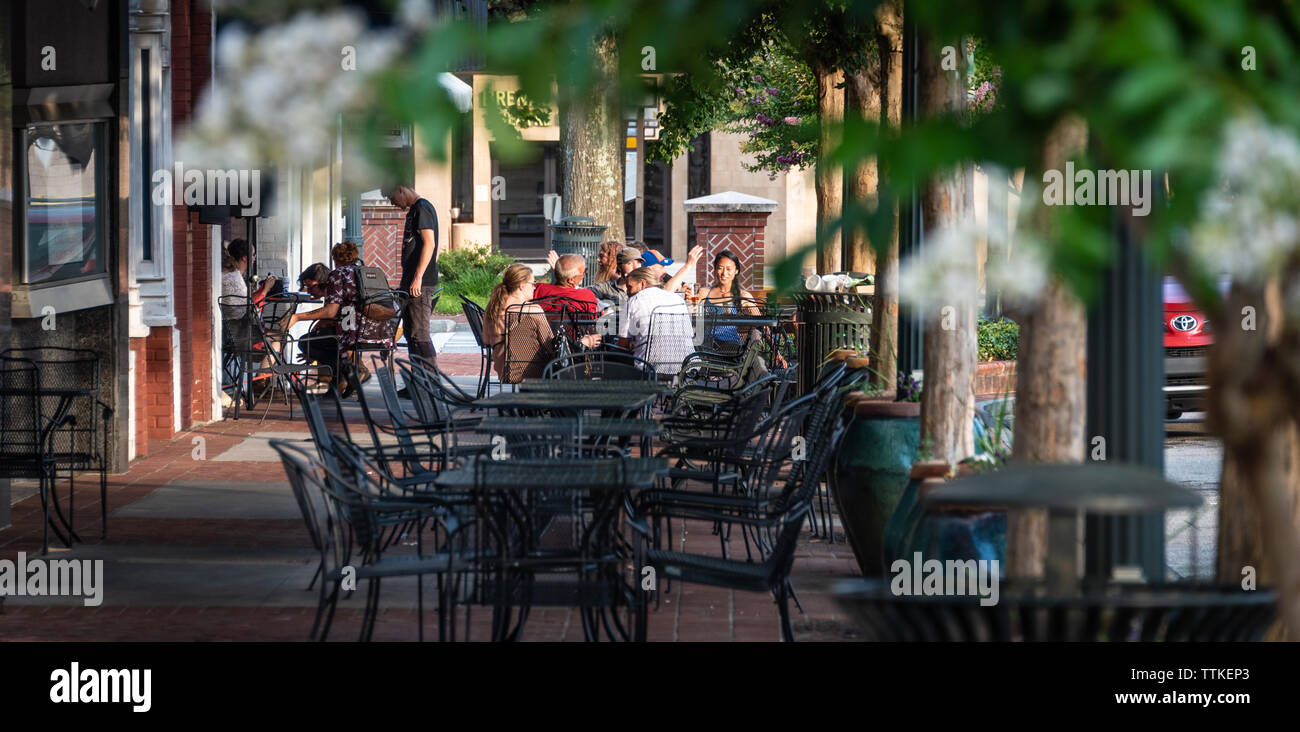 Friends gathering around sidewalk tables at Downtown Drafts on the historic town square in Gainesville, Georgia. (USA) Stock Photo