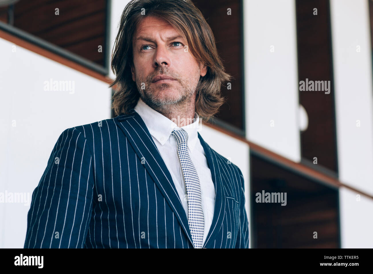 Thoughtful businessman standing in office Stock Photo