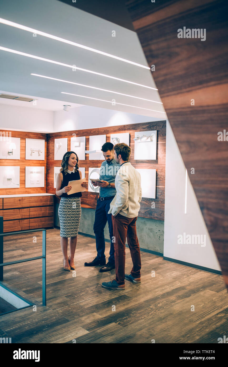 Happy business people discussing while standing in office Stock Photo