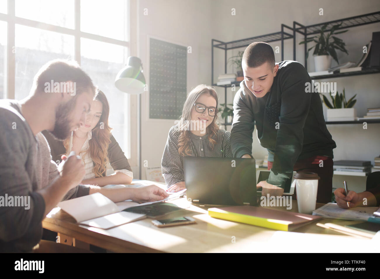 Friends discussing while studying in classroom Stock Photo