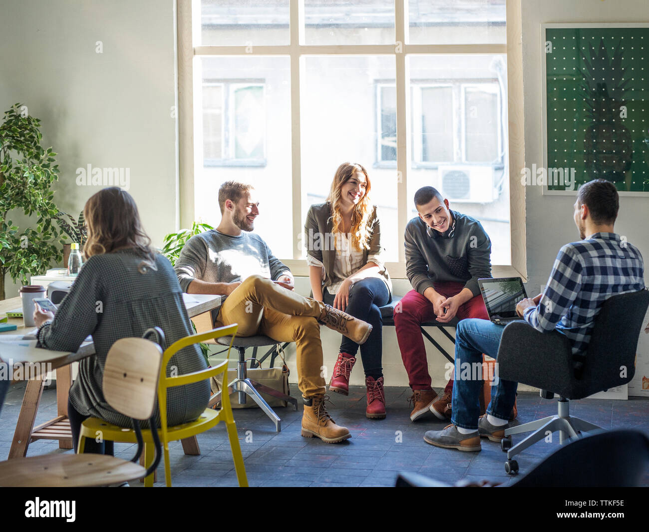 Friends discussing while sitting in classroom Stock Photo