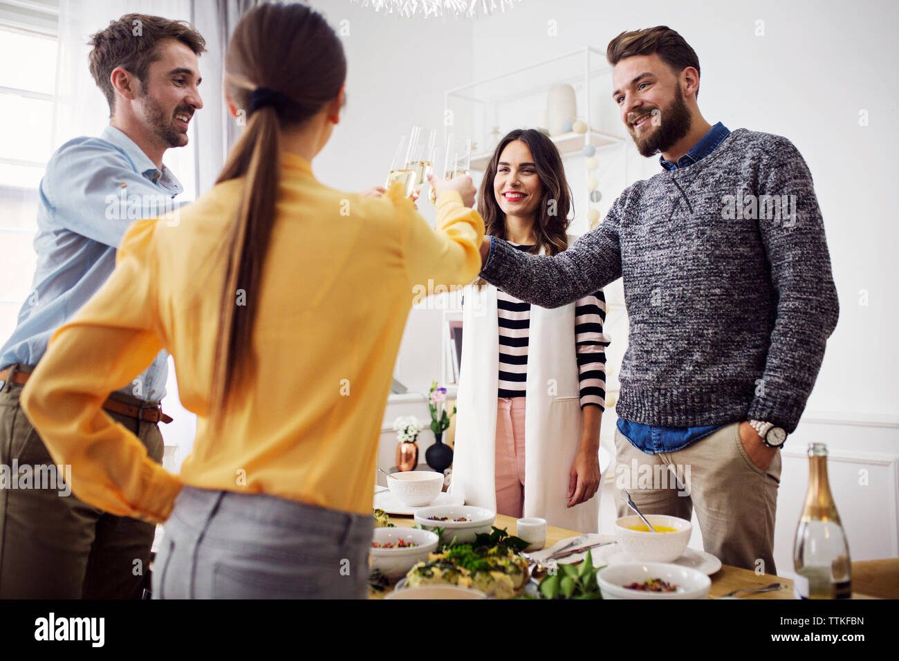 Happy friends raising celebratory toast in lunch party Stock Photo