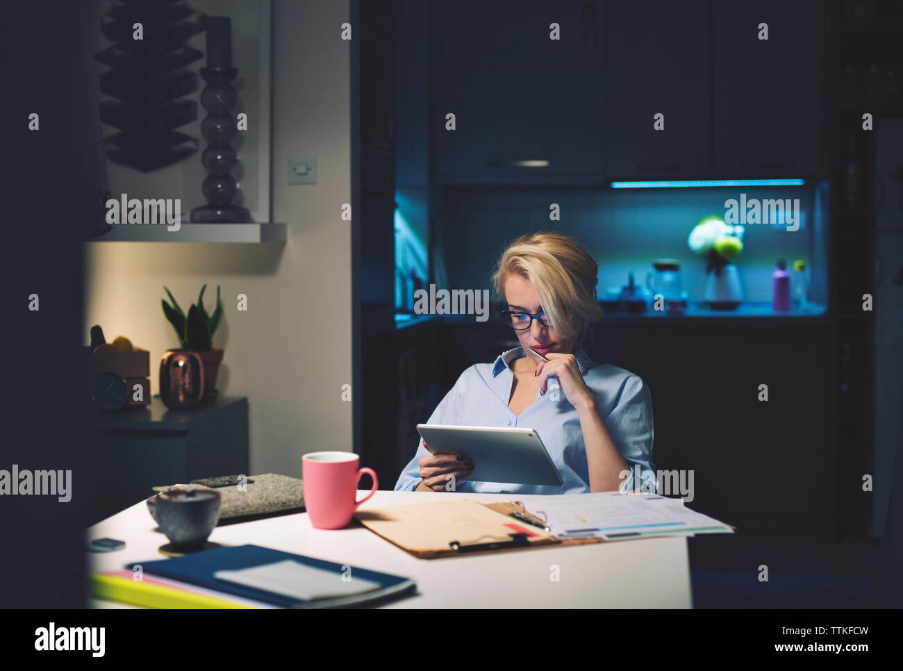 businesswoman using tablet computer while sitting at desk Stock Photo