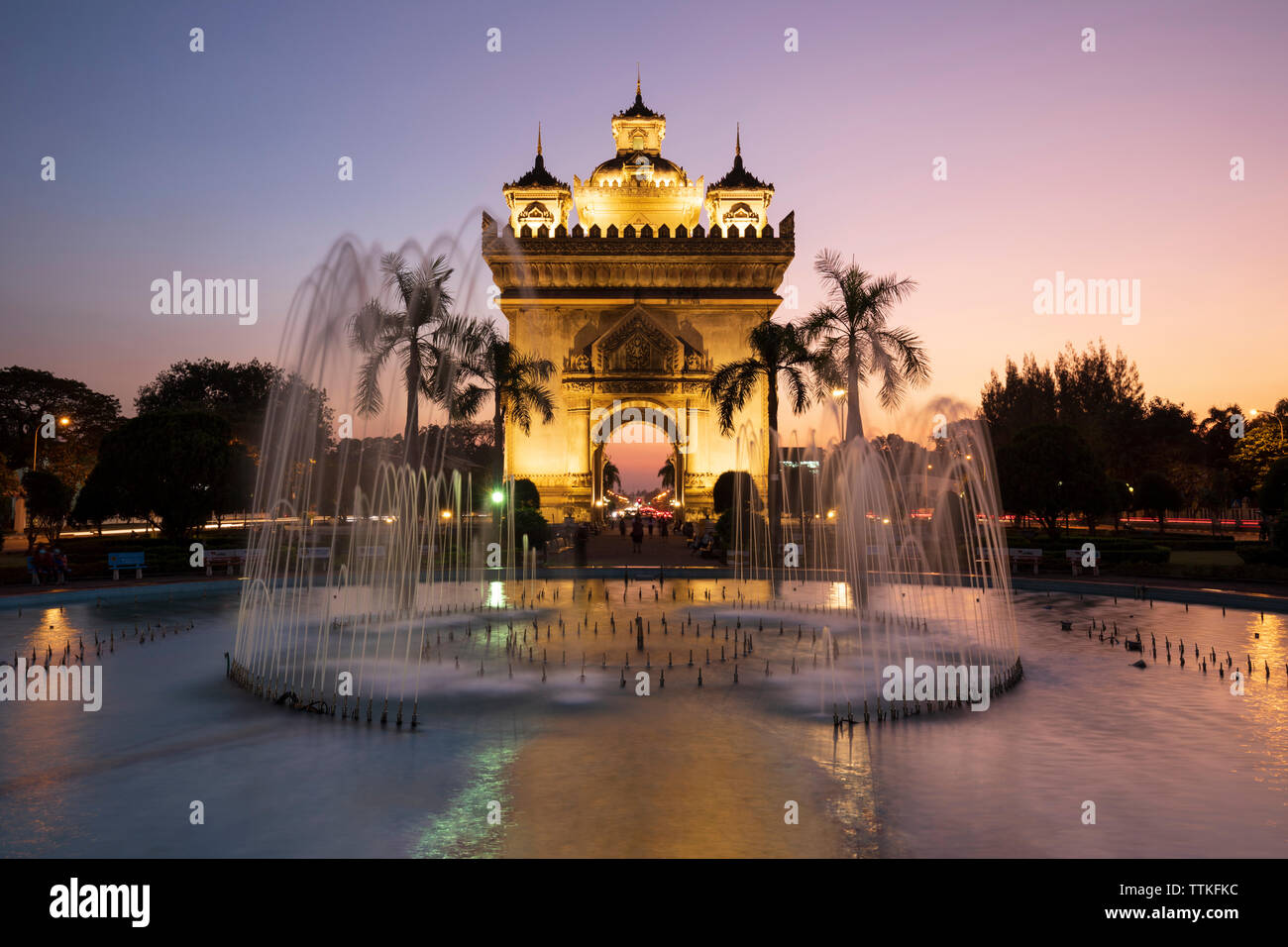 Patuxai Victory Monument (Vientiane Arc de Triomphe) and fountain floodlit at dusk, Vientiane, Laos, Southeast Asia Stock Photo