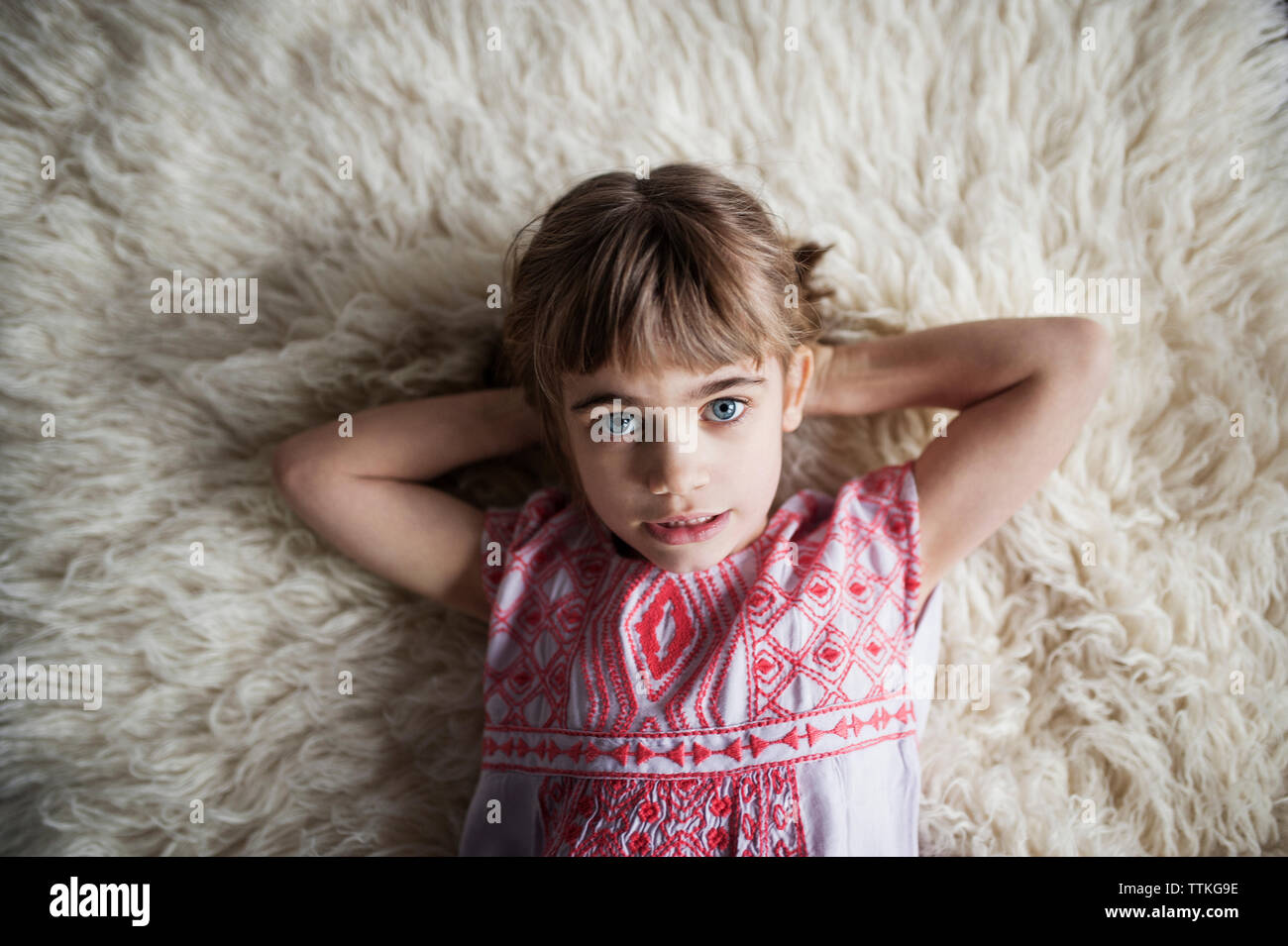 Overhead view of girl lying on rug at home Stock Photo Alamy