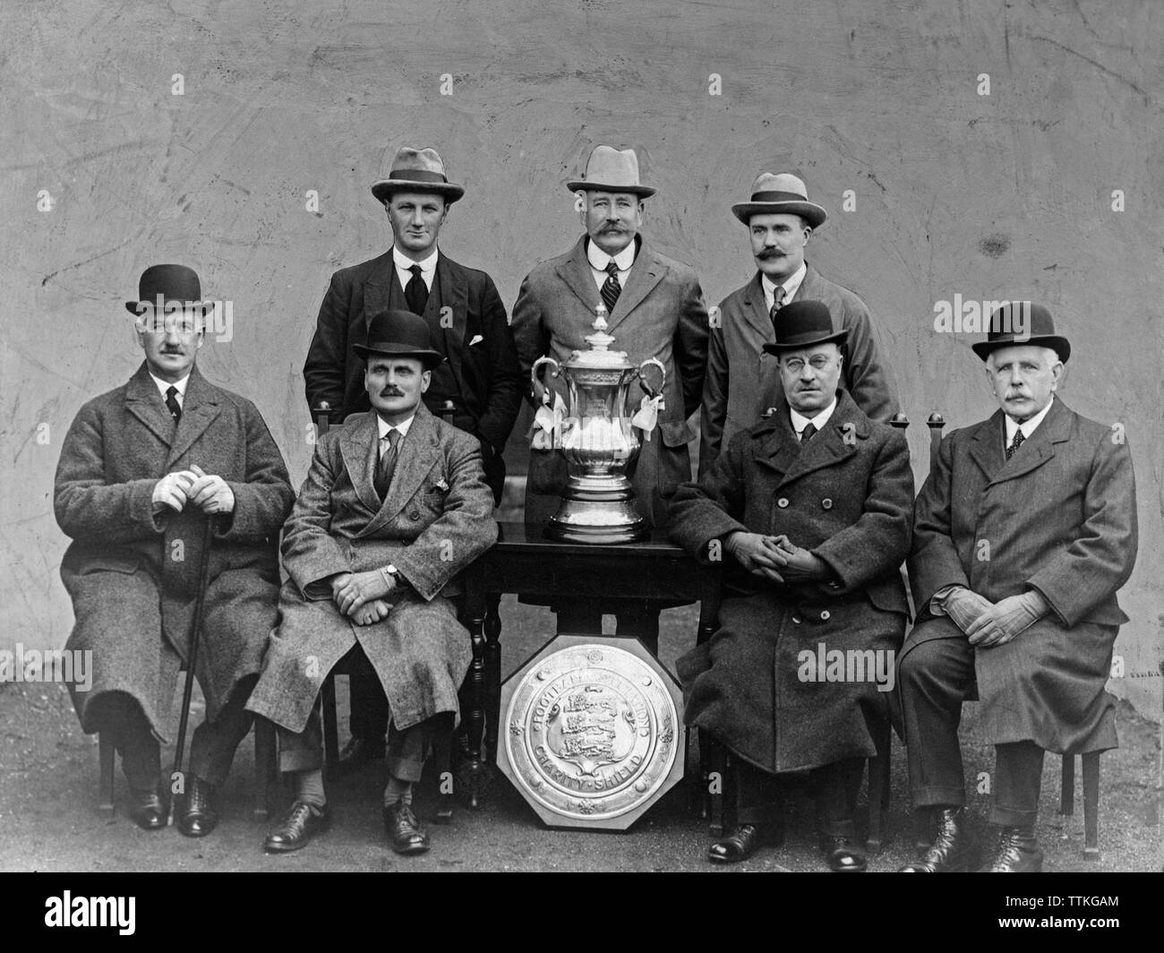 A vintage black and white photograph showing members of the English Football Association with the FA Cup trophy and Charity Shield. Photograph taken during the 1920s or 1930s. Stock Photo