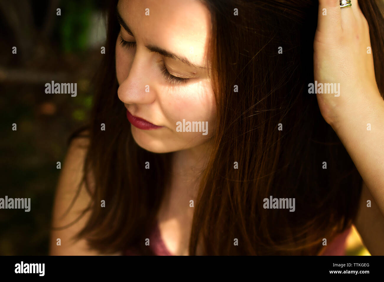 Close-up of woman with hand in hair Stock Photo