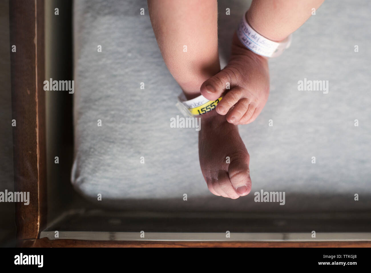 Low section of newborn lying in crib at hospital Stock Photo Alamy