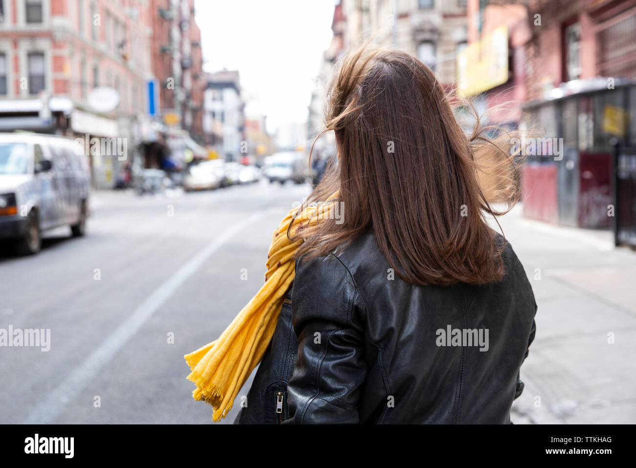 Rear view of woman walking on city street Stock Photo - Alamy