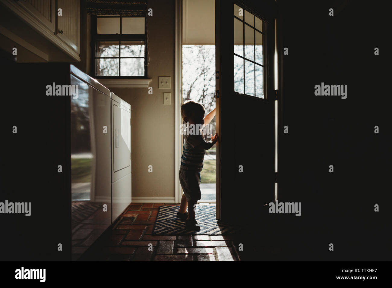 Side view of silhouette baby boy standing at doorway Stock Photo - Alamy
