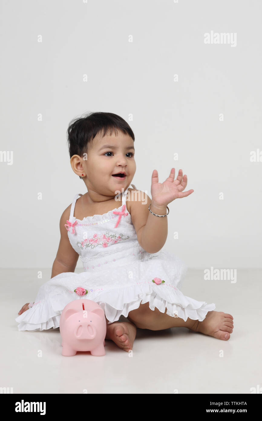 Baby girl playing with a piggy bank Stock Photo - Alamy