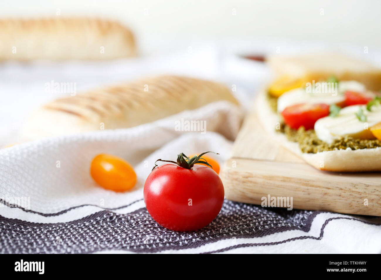 Close-up of panini served on cutting board with napkin on table Stock Photo