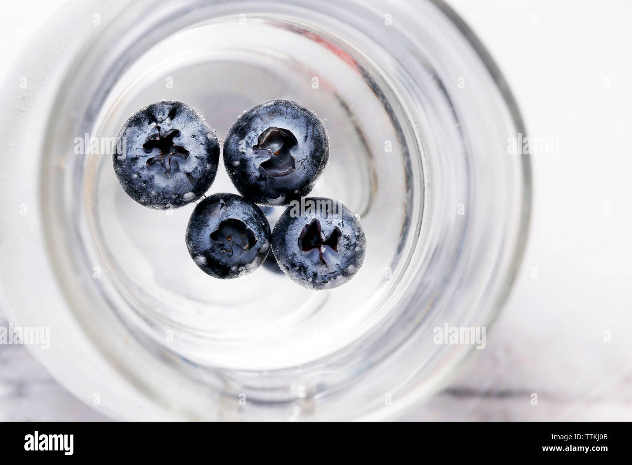Overhead view of blueberries in water jug on table Stock Photo