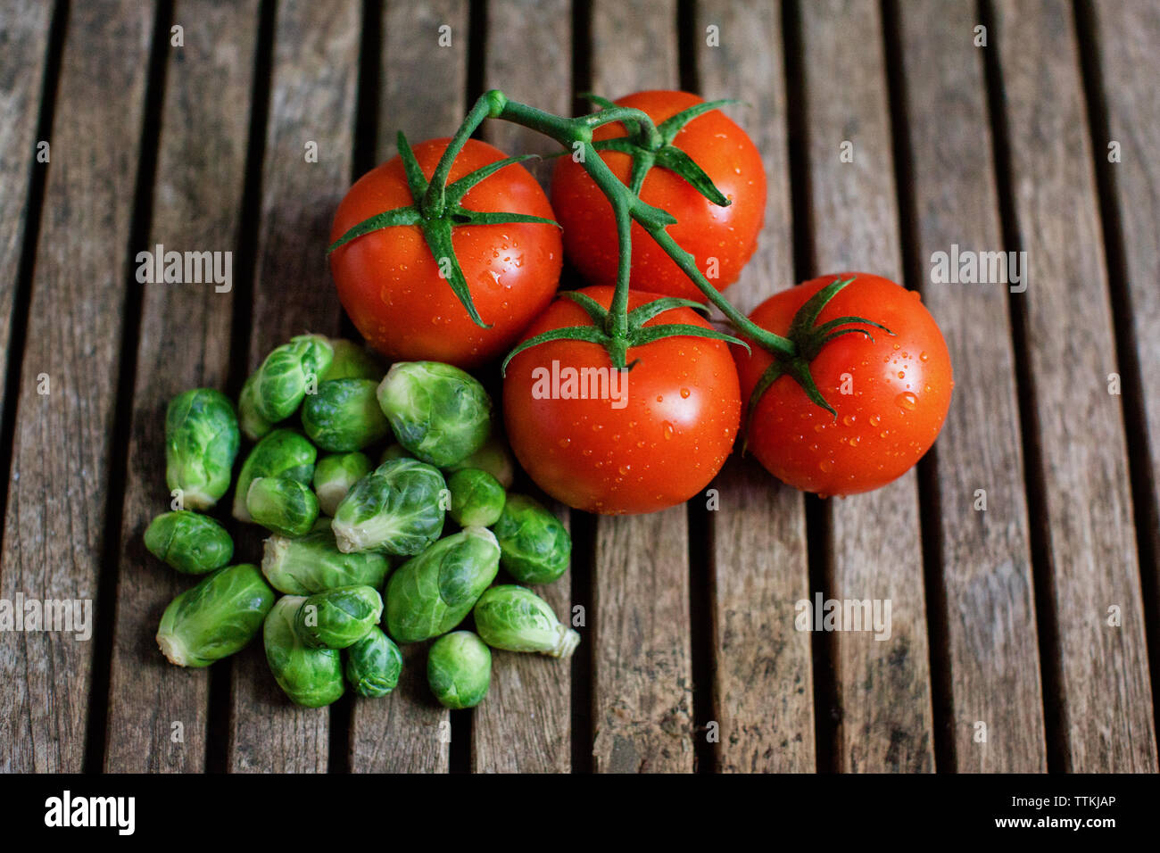 Overhead view of fresh tomatoes and small cabbages on wooden table Stock Photo