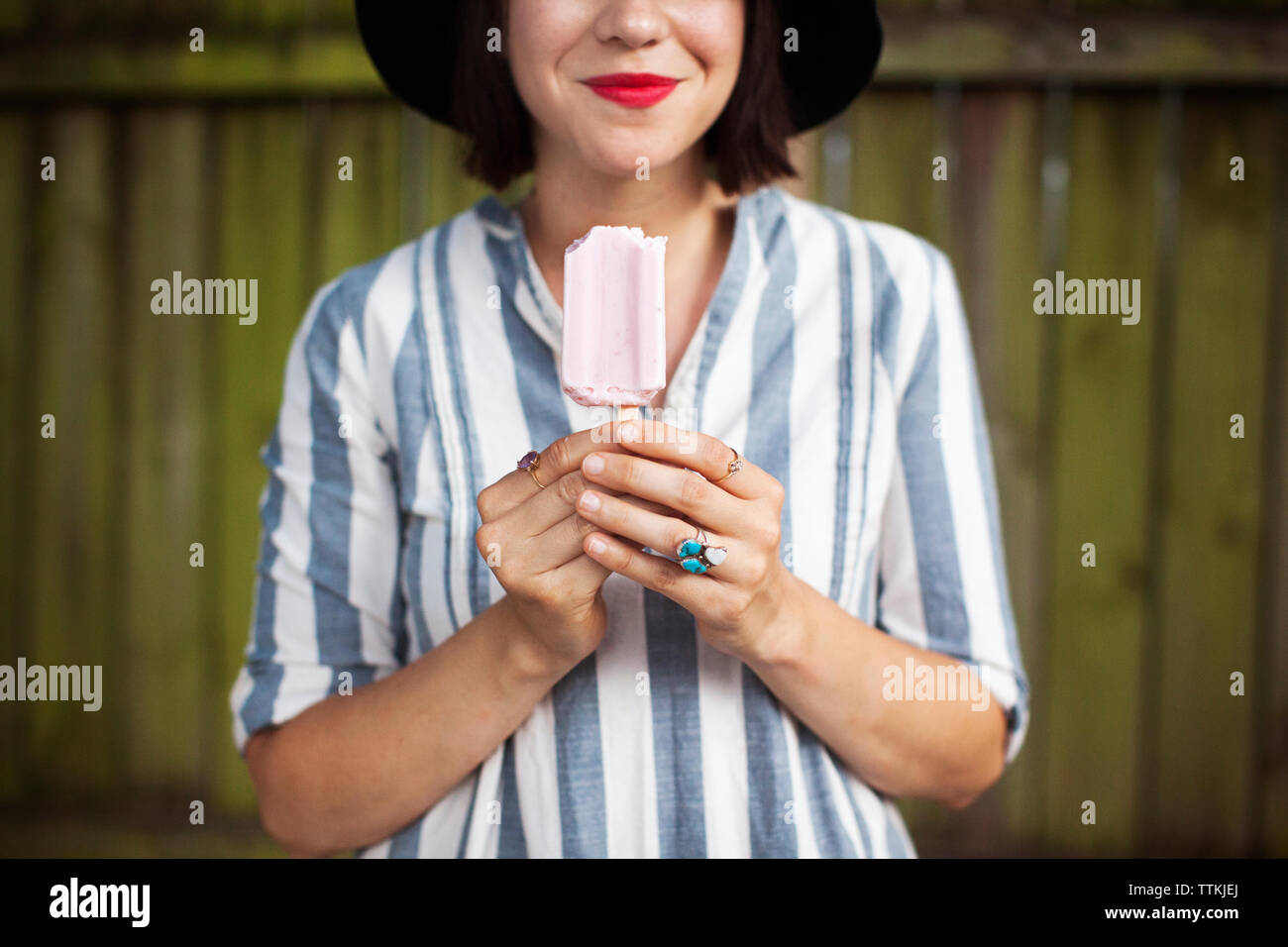 Midsection of smiling woman holding popsicle Stock Photo