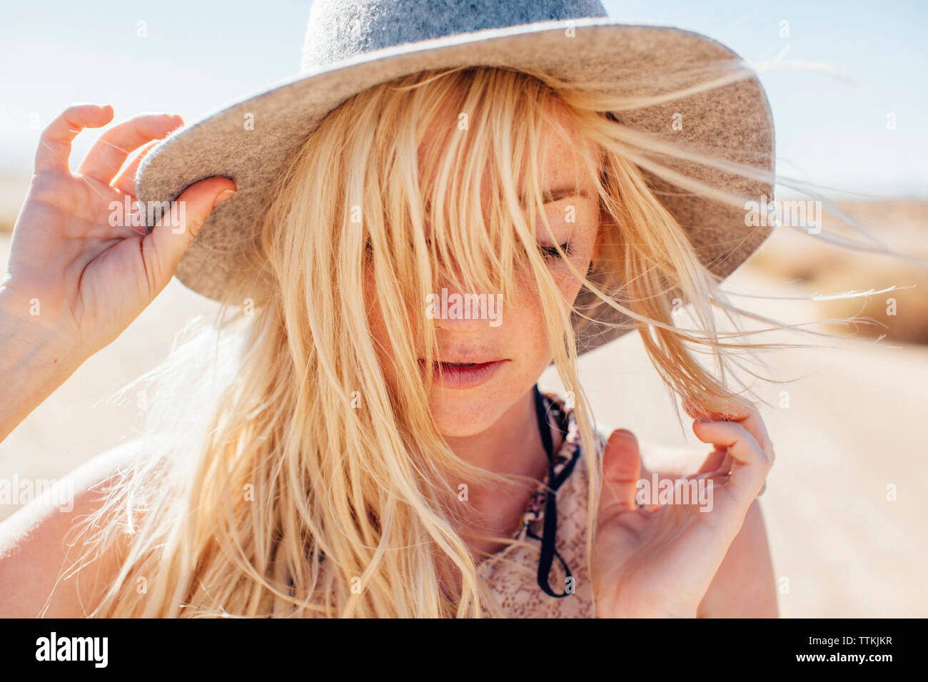 Close-up of woman in sun hat enjoying vacation at desert on sunny day Stock Photo