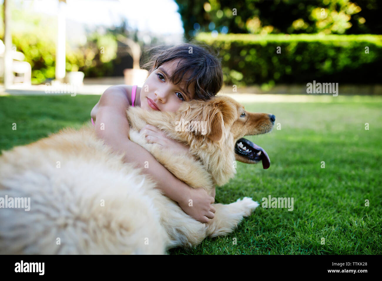Girl resting with dog in yard Stock Photo - Alamy
