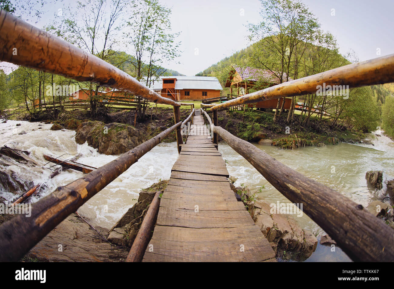 Old wooden bridge over the mountain stream Stock Photo - Alamy