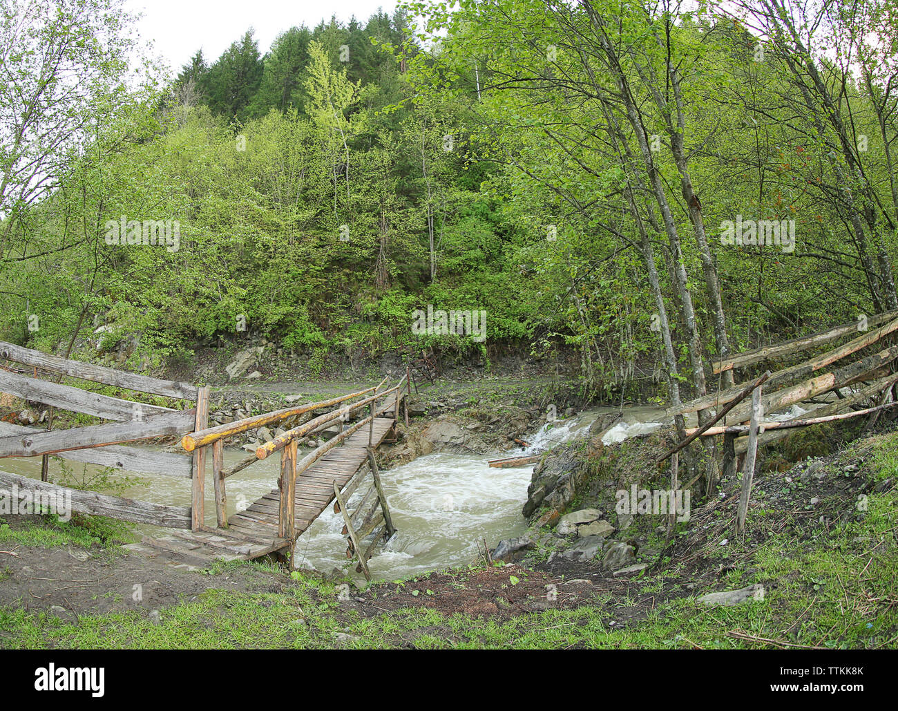 Old wooden bridge over the mountain stream Stock Photo - Alamy