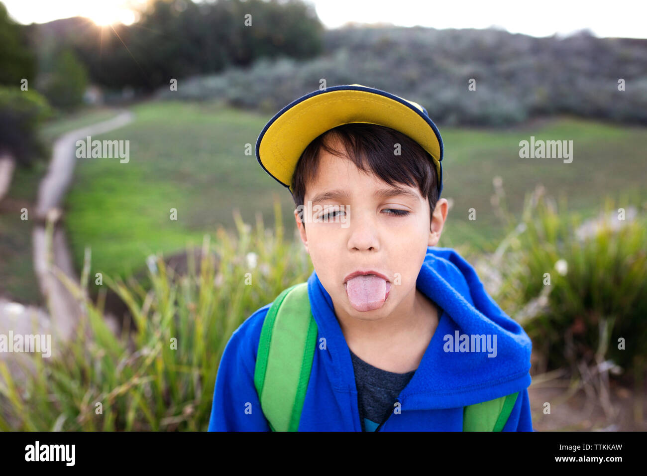 Close-up of boy sticking out tongue on field Stock Photo