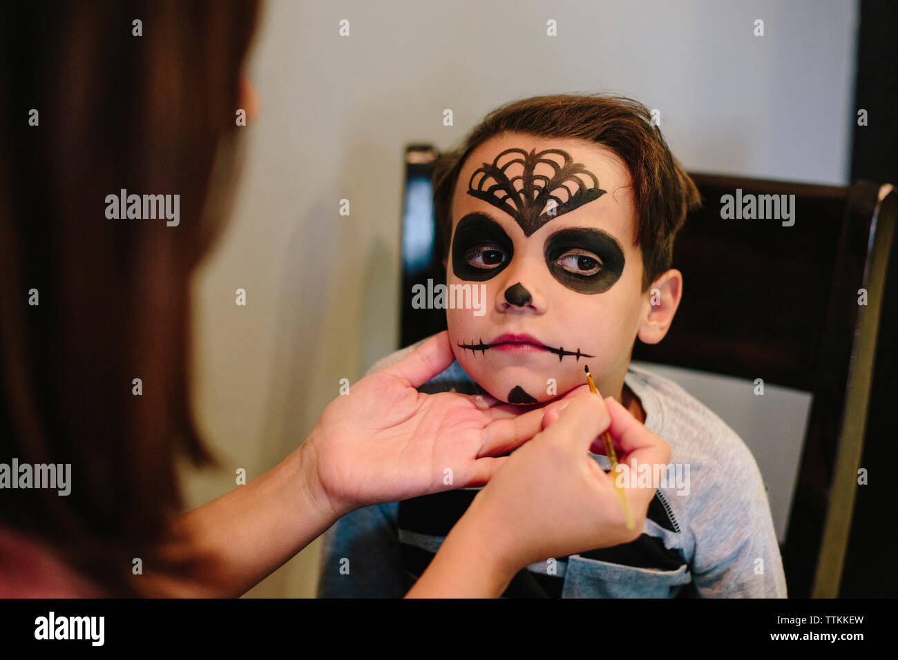 Mother applying make-up on son's face at home Stock Photo