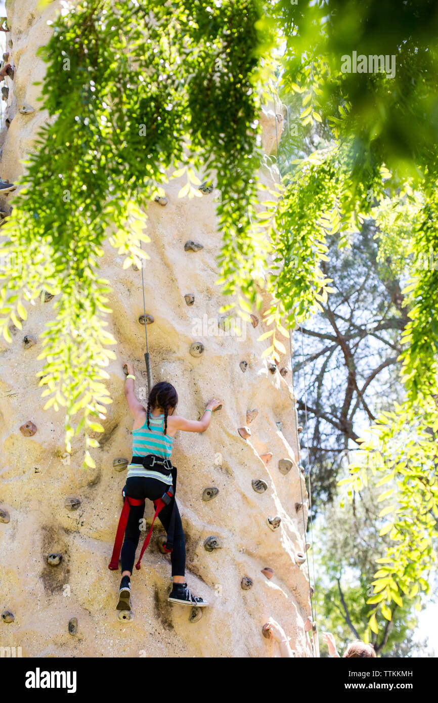 Rear view of girl climbing rock wall at playground Stock Photo