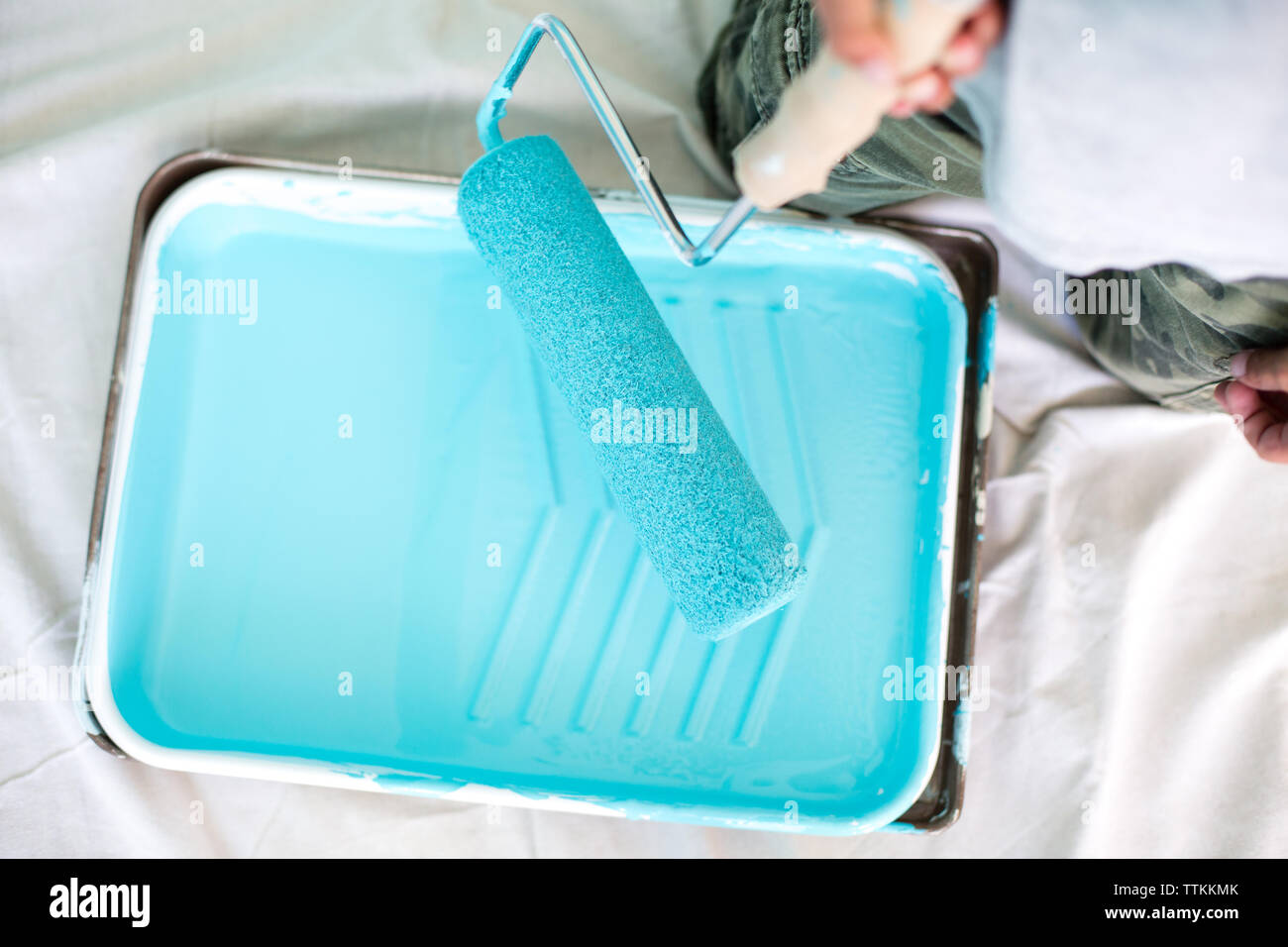 Midsection of boy holding paint roller over tray at home Stock Photo