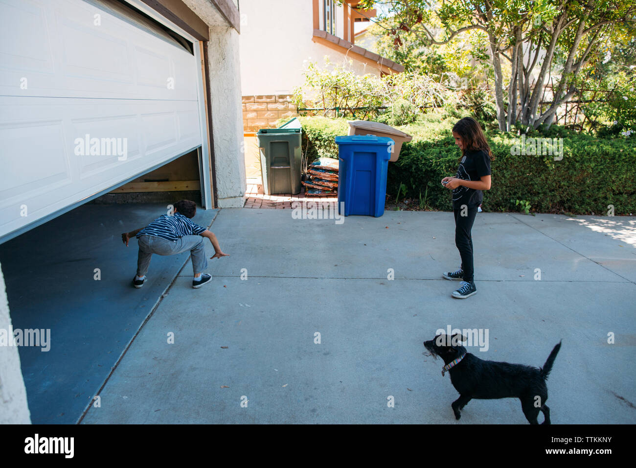 Sister looking at brother walking in through automatic door Stock Photo(01)