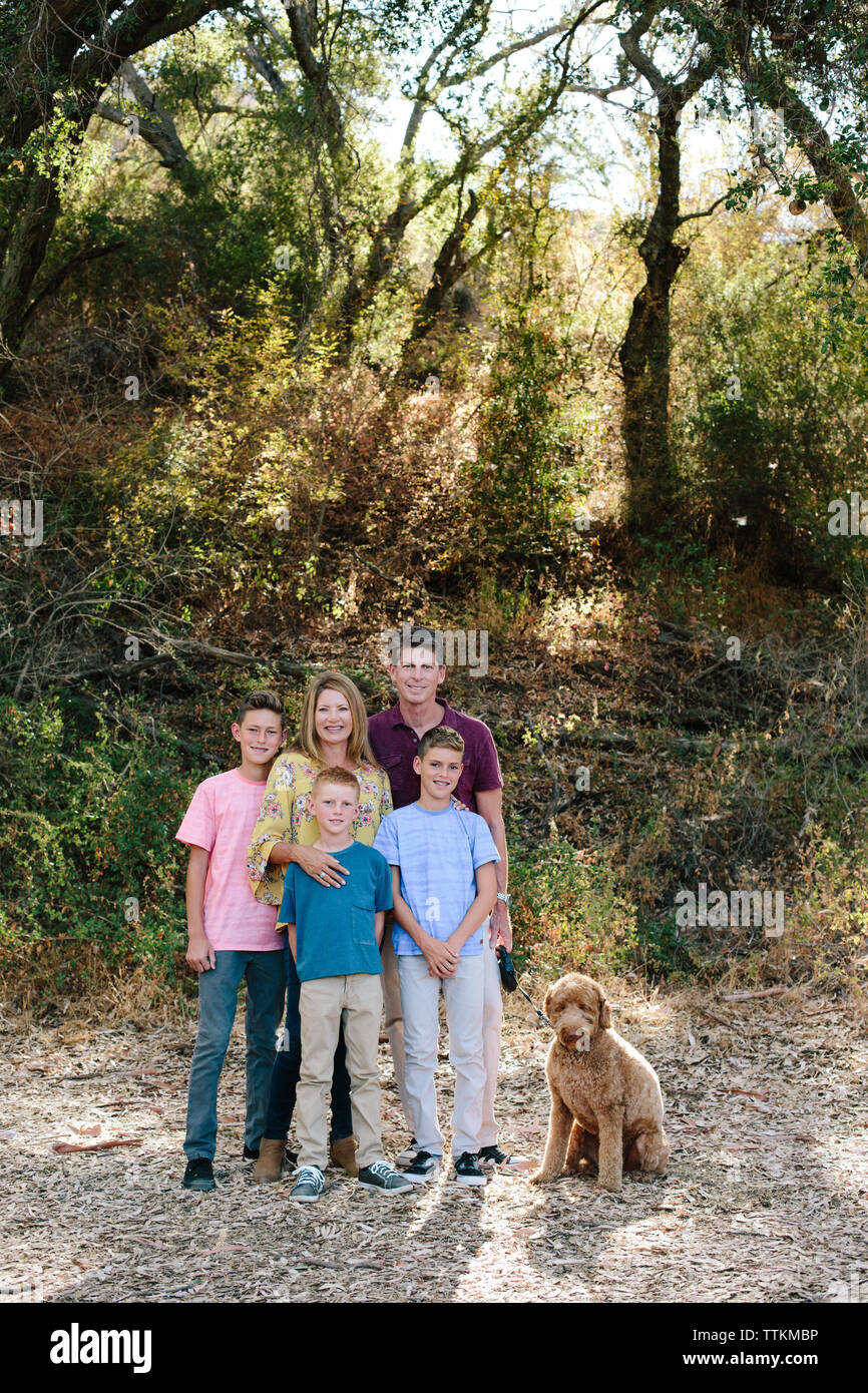 Family of five smile for a portrait with pet labradoodle Stock Photo