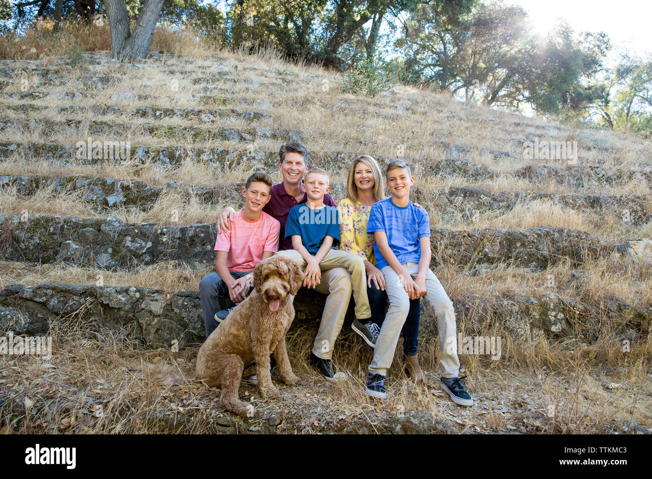 Family of 5 smile for a family portrait with dog in nature Stock Photo