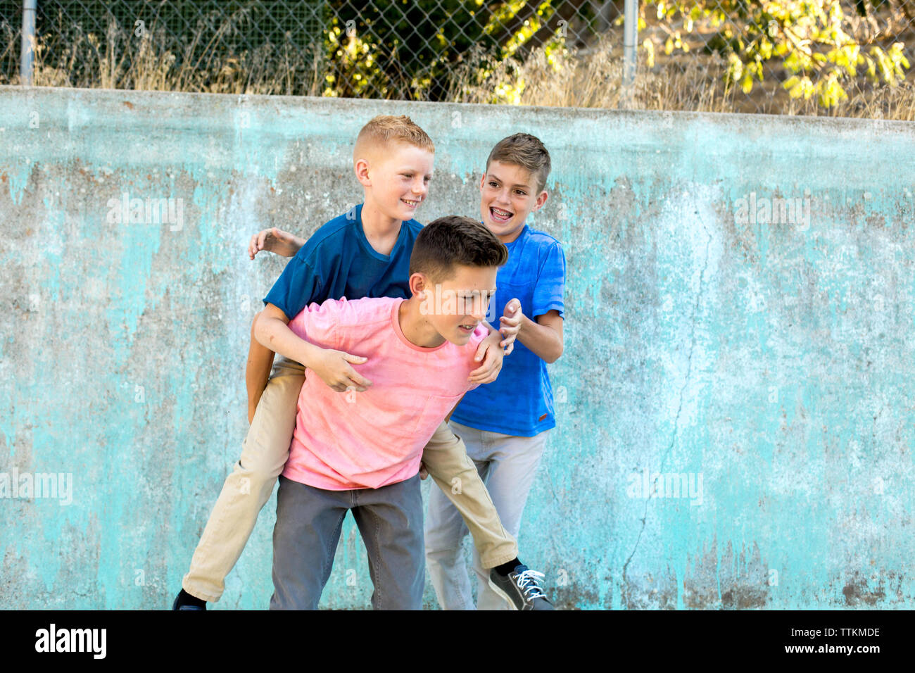 Boy on piggyback anticipates the actions of his older brother Stock Photo