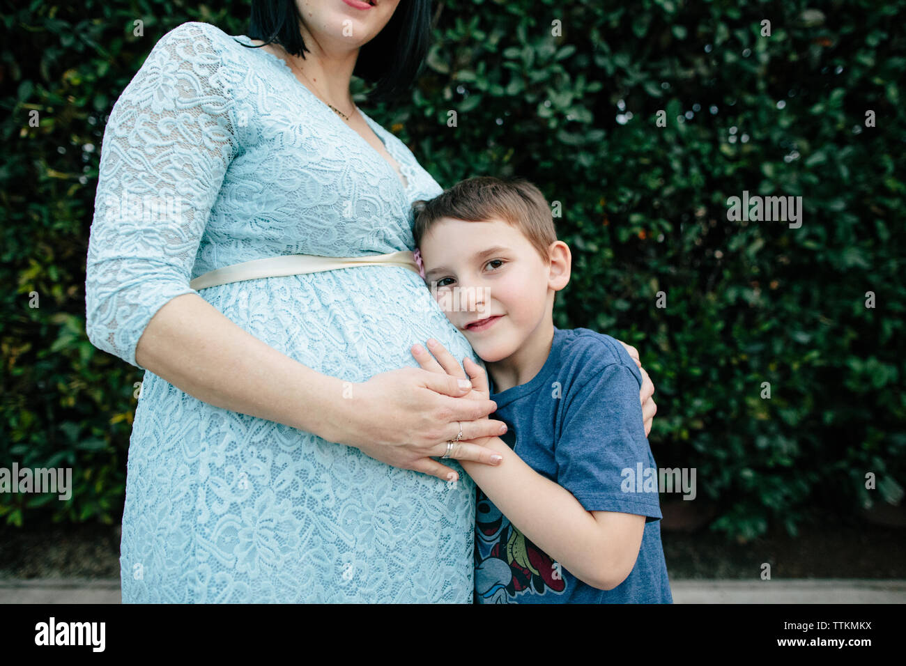 Soon to be big brother rests head on mother's baby bump Stock Photo