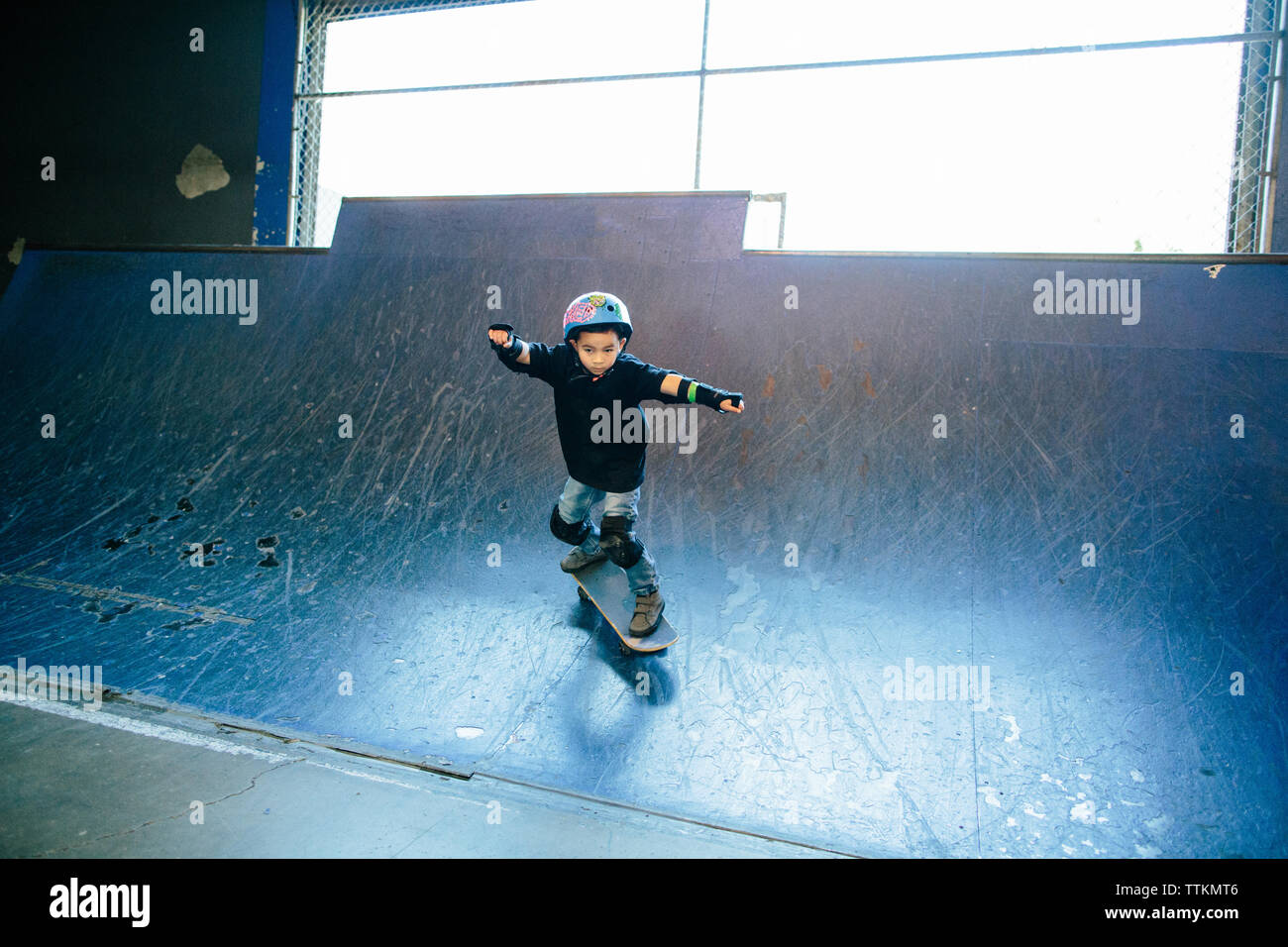 Young boy skateboarding down a blue skate ramp Stock Photo - Alamy