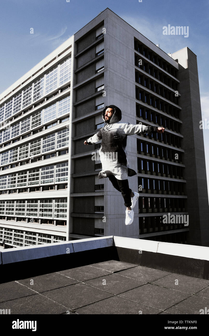 Man jumping on terrace against building Stock Photo