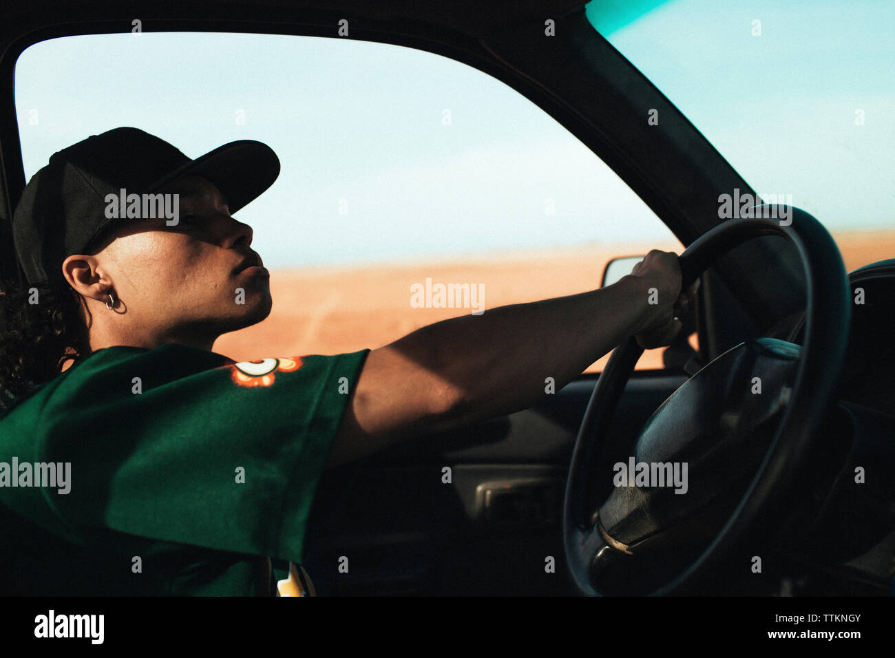Side view of young man driving car Stock Photo